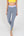 Eine Frau trägt eine graue Sportleggings mit einem lavendel Bund und einem gelben Akzentstreifen mit Bodyguard-Logo am Bein unten.