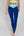 Eine Frau trägt eine dunkelblaue Sportleggings mit einem hellblauen Bund und einem gelben Akzentstreifen mit Bodyguard-Logoam Bein unten
